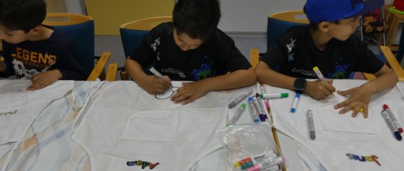 Kinder bemalen ihre eigenen Schürzen