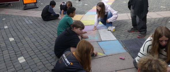 Schülerinnen und Schüler beim Bemalen des Exerzierplatzes