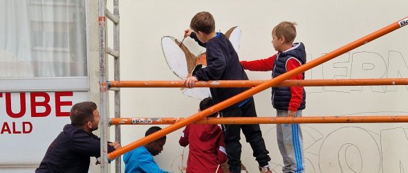 Die Kinder der Lernstube Sommerwald beim Bemalen der Außenwand