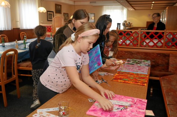 Kinder sortieren ihre erstellen Kunstwerke beim TVP