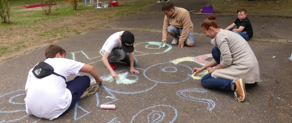 Kinder malen mit Kreide beim School's out-Event