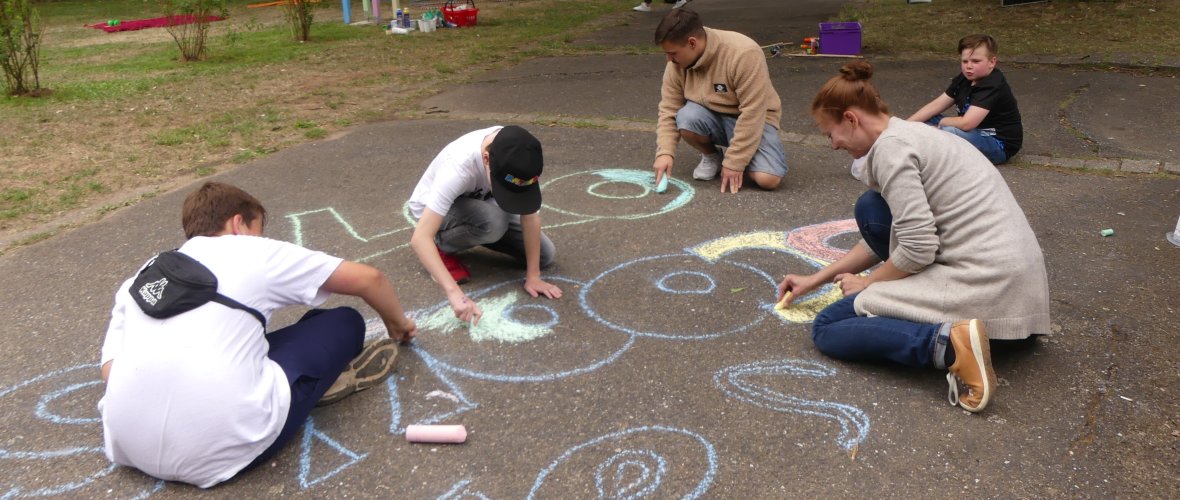 Der Wedebrunnen-Park wird mit Kreide verschönert Kinder malen mit Kreide beim School's out-Event