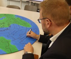 Oberbürgermeister Markus schreibt auf eine Weltkugel Oberbürgermeister Markus schreibt auf eine Weltkugel