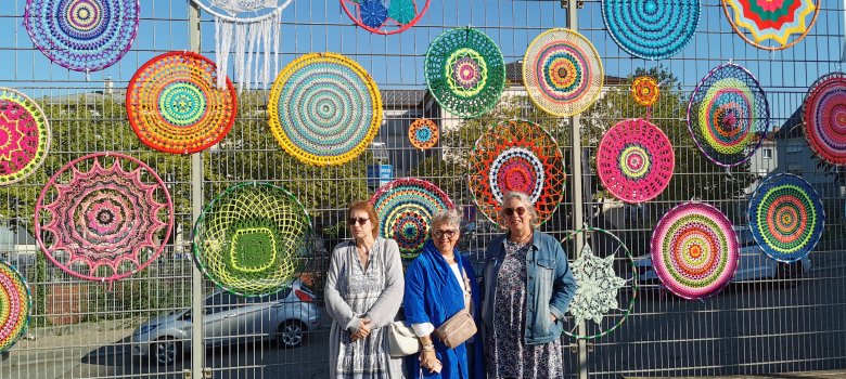 Hula-Hoop-Reifen welche umhäkelt sind mit Mitgliedern des Strickkreises.